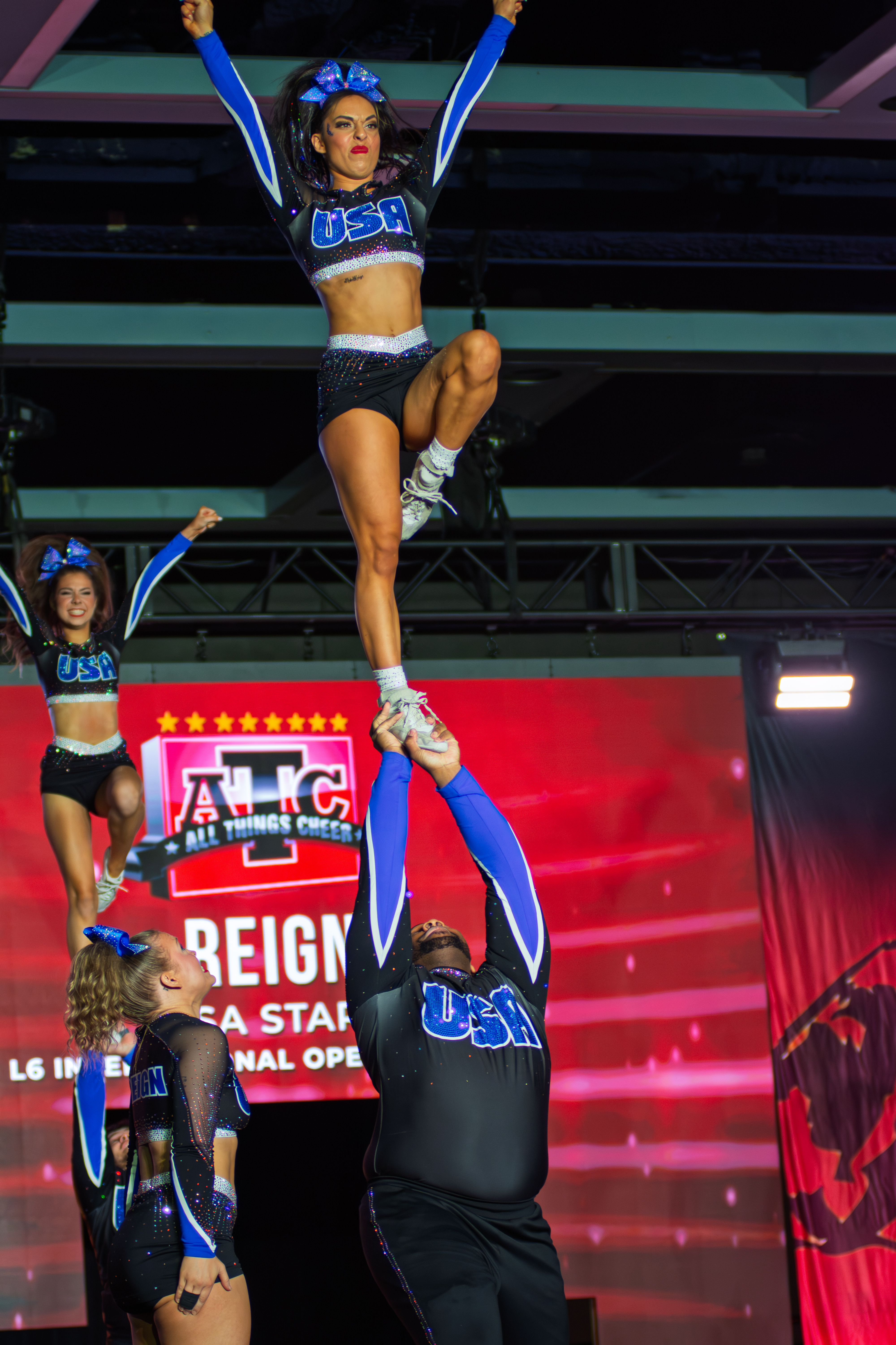 Energetic cheer squad mid-routine showing athletic skill - competitive cheer action photography