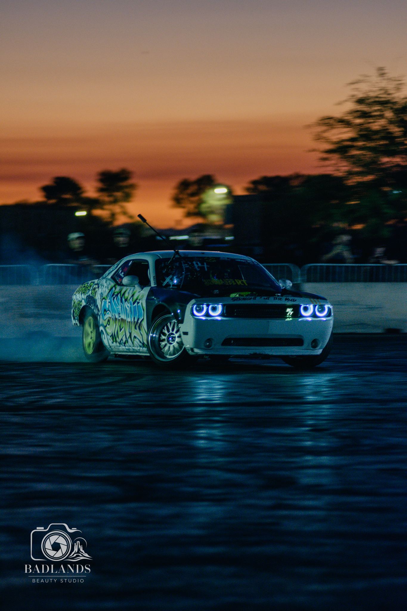 Wrapped muscle car under an orange sunset sky